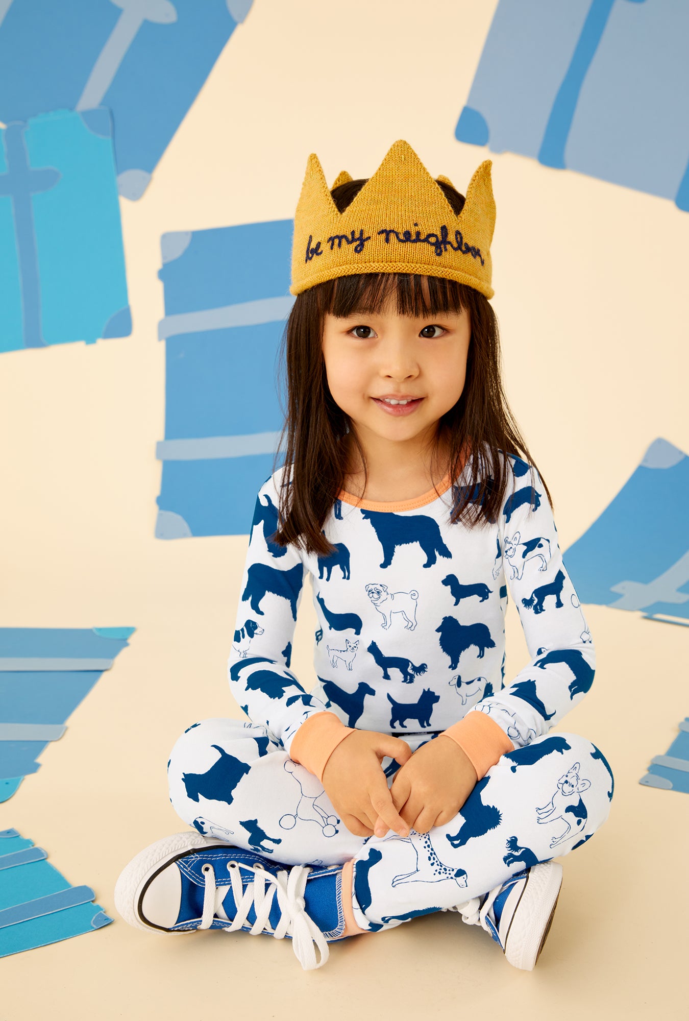 A kid wearing a white long sleeve pajama set with dog pattern.