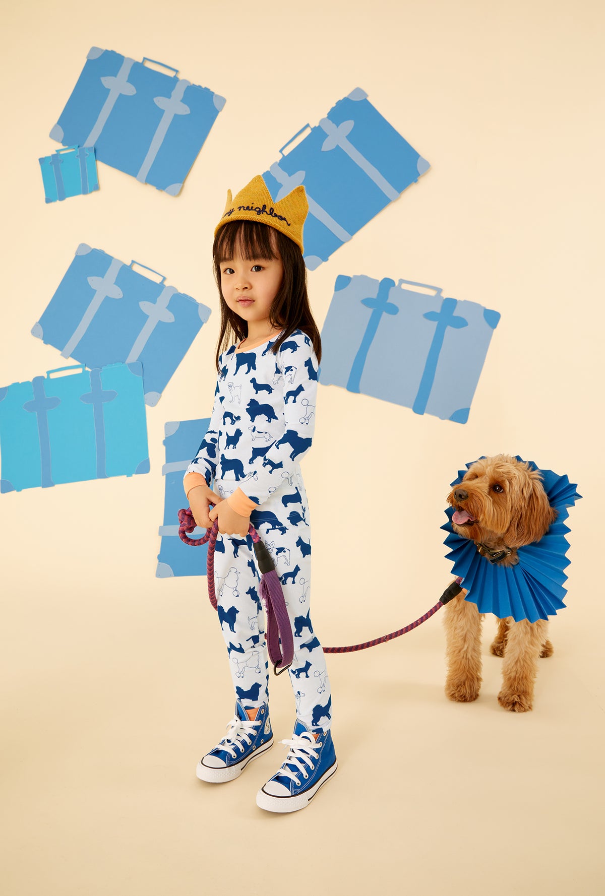 A kid wearing a white long sleeve pajama set with dog pattern.