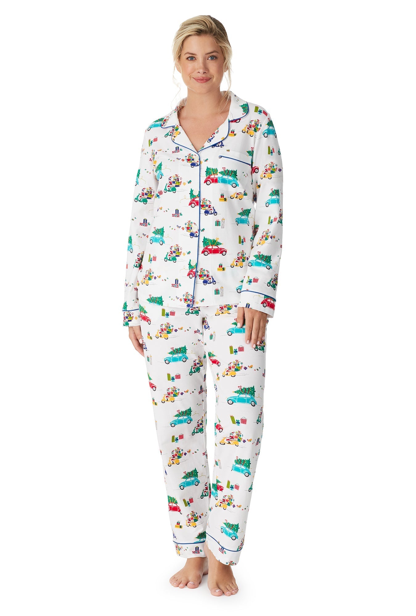 A lady wearing a white long sleeve pj set with readying for christmas views pattern.