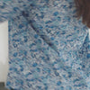 A lady wearing a long sleeve pj set with blue floral pattern.
