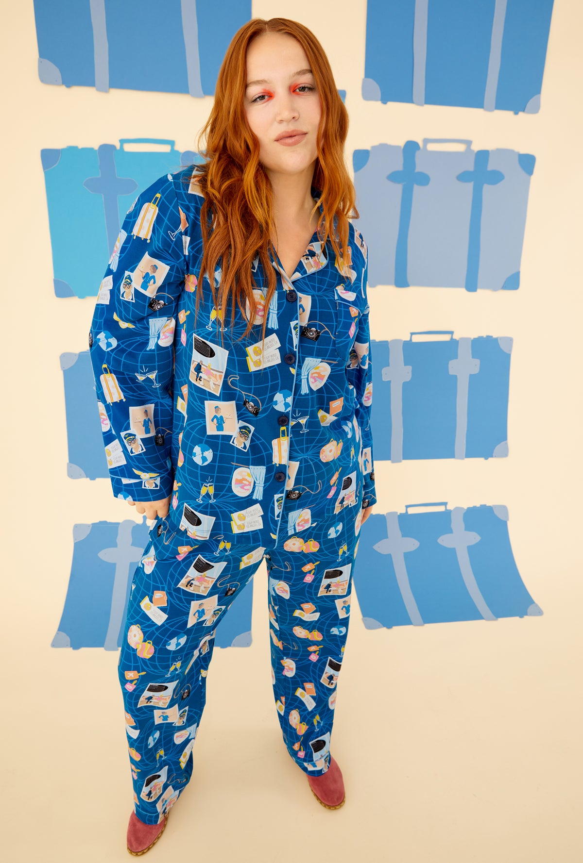 A lady wearing a blue long sleeve pajama set plus with jet setter pattern.