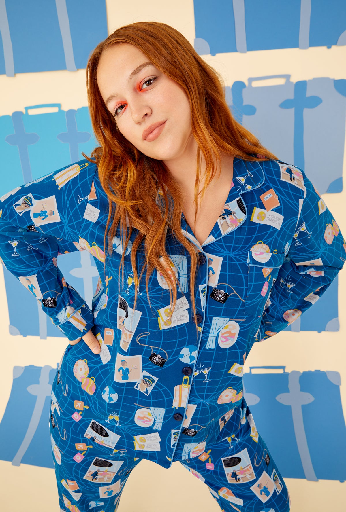 A lady wearing a blue long sleeve pajama set plus with jet setter pattern.