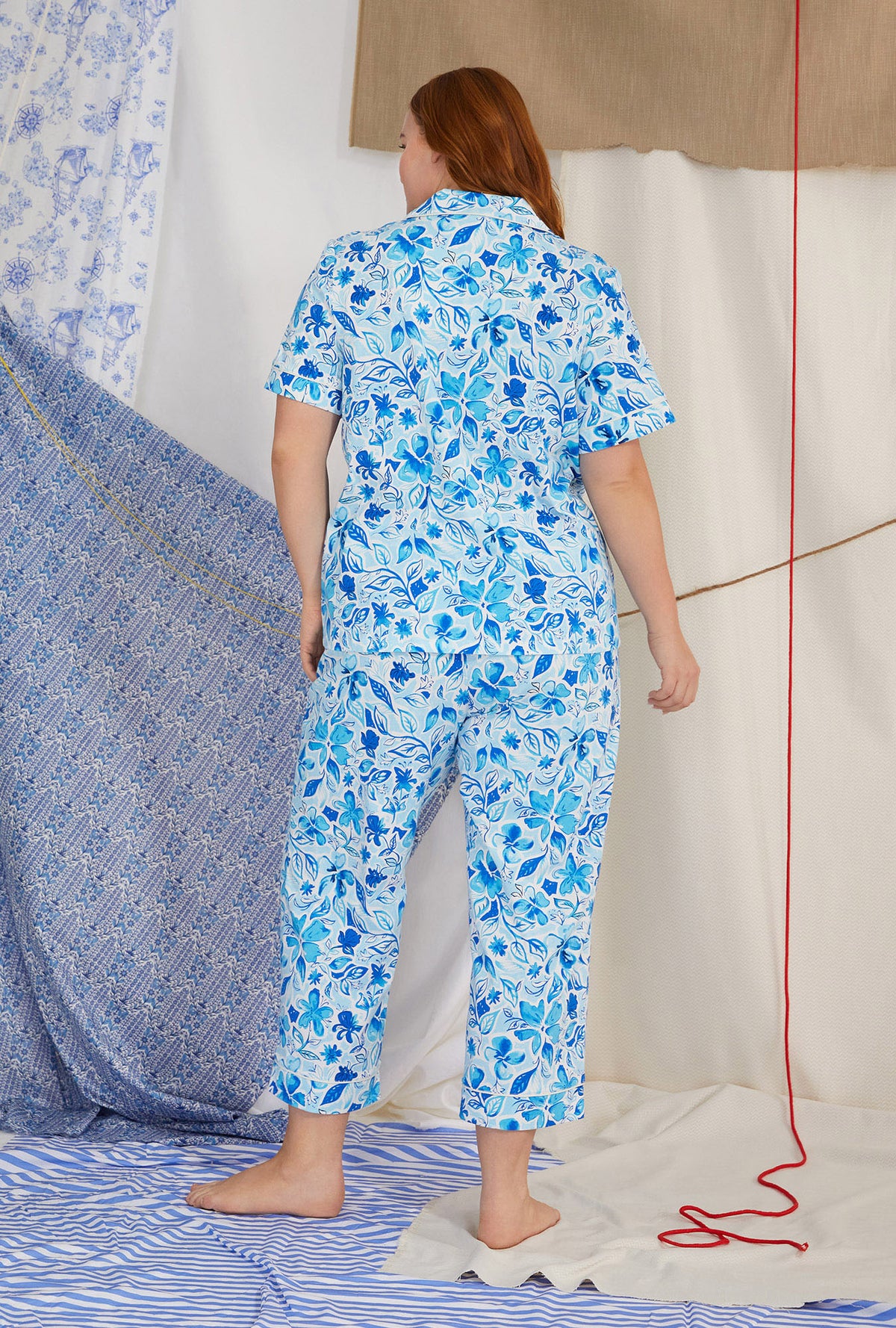 A lady wearing white short sleeve classic cropped plus size pj set with marine meadows print.