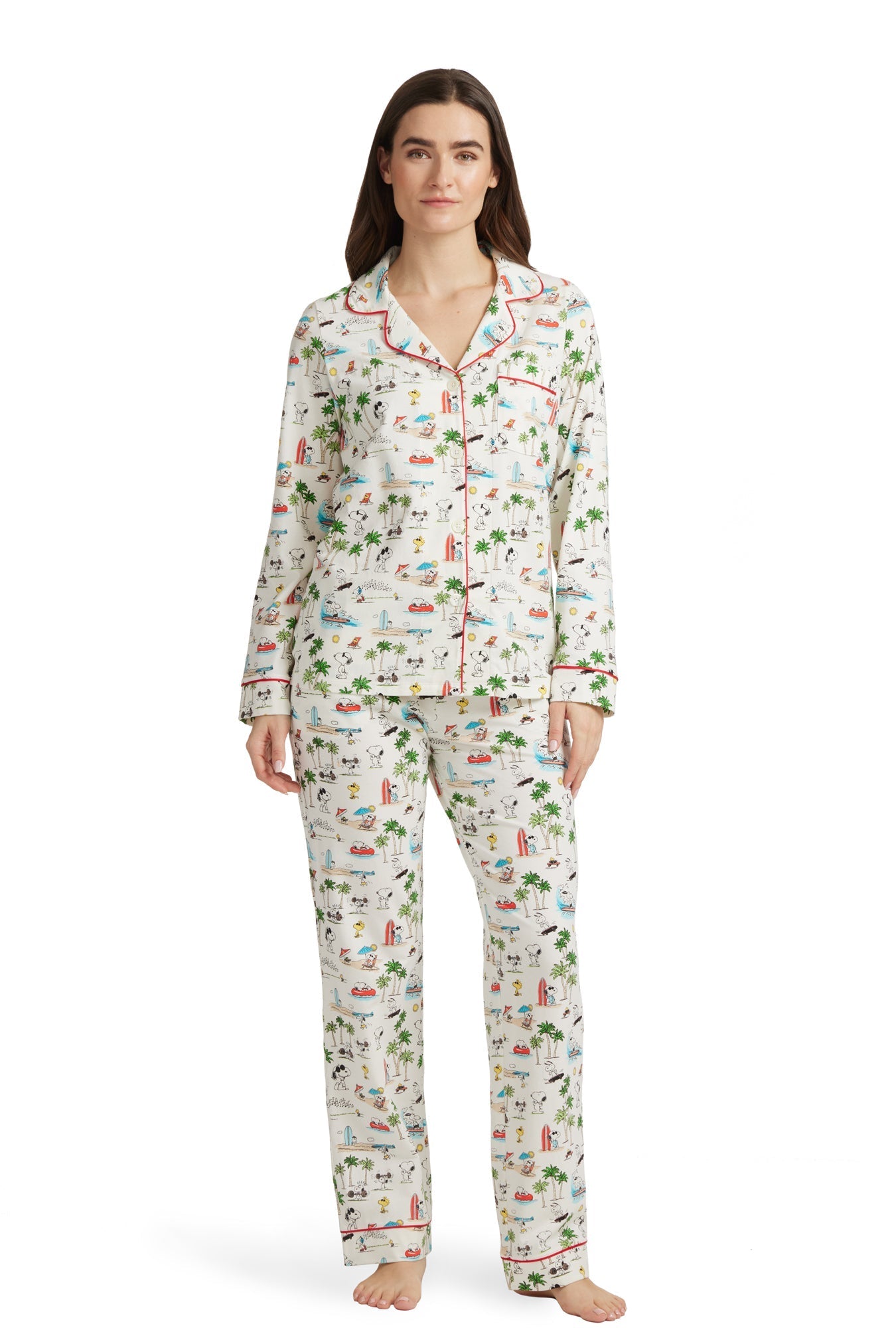 A lady wearing a white long sleeve pj set with snoopy venice beach pattern.