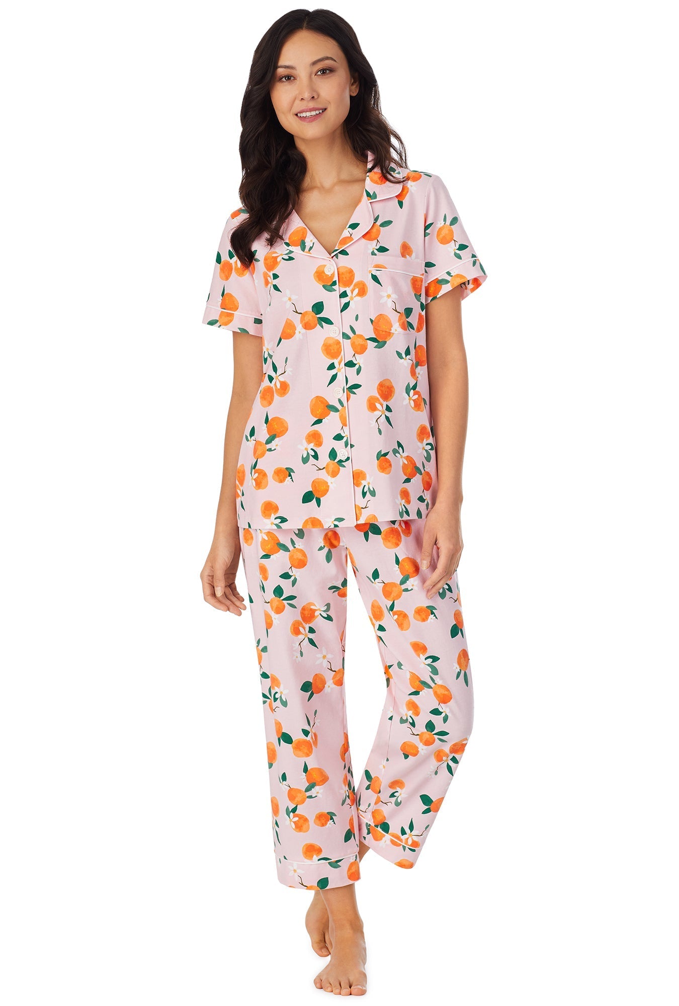 A lady wearing a pink short sleeve pj set with orange blossom pattern.