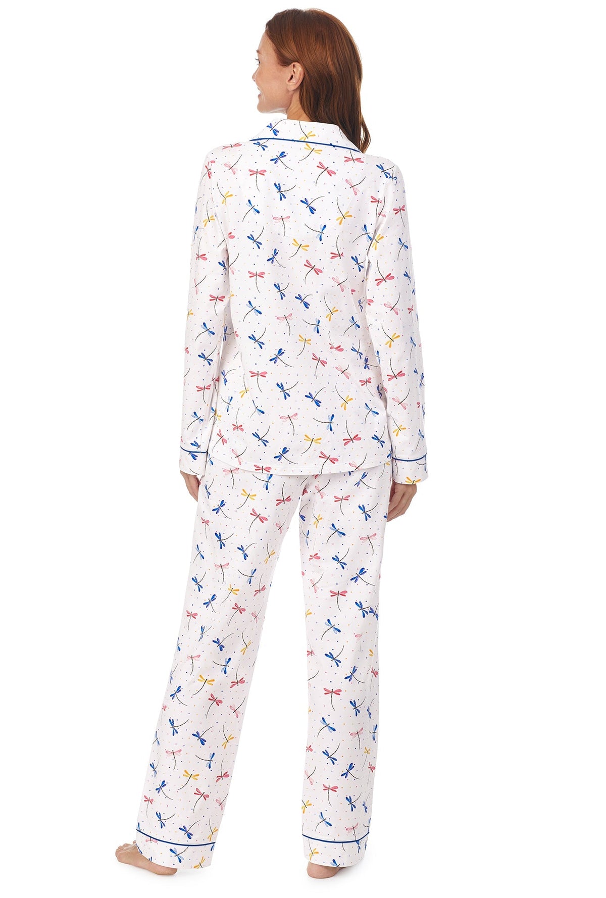 A lady wearing a white long sleeve pj set with dragonfly pattern.