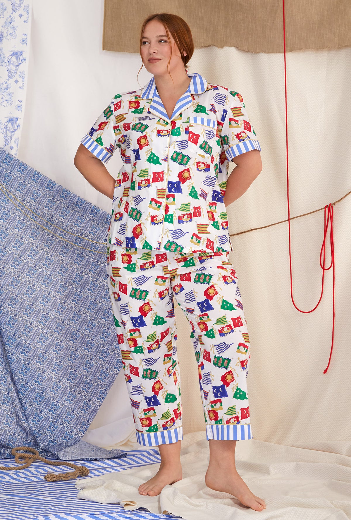 A lady wearing white short sleeve classic cropped plus size pj set with nautical flags print.