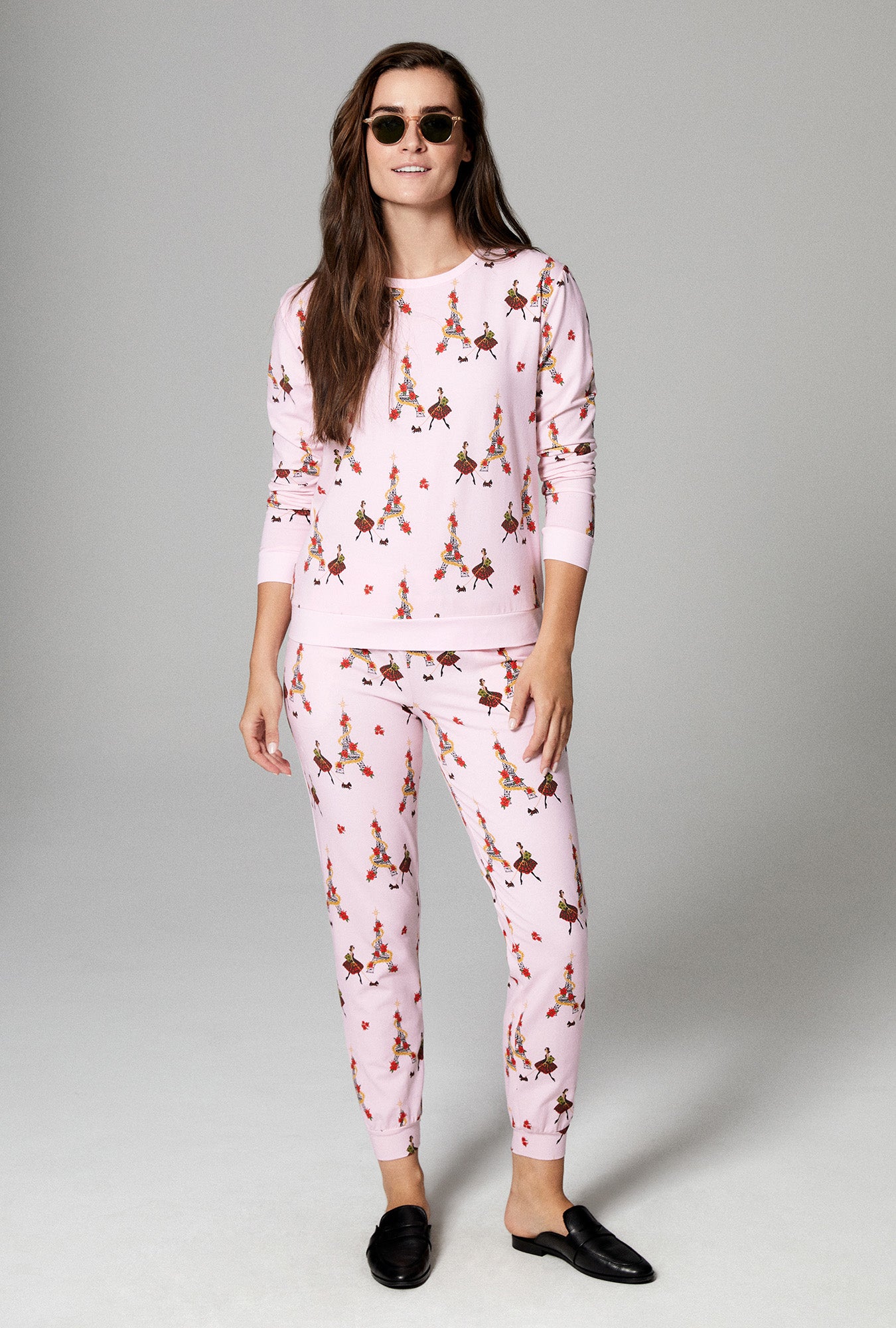 A lady wearing pink long sleeve pullover crew and jogger stretch jersey pj set with christmas chic print.