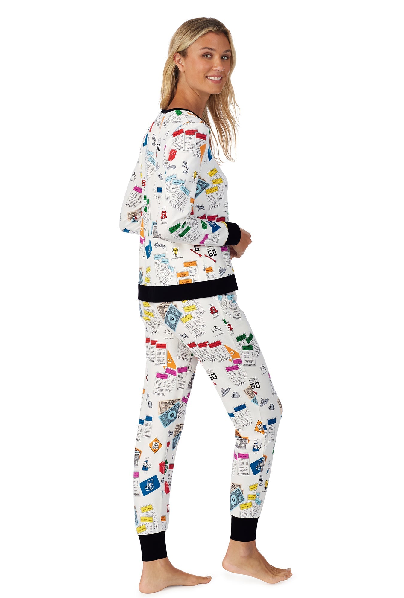 A lady wearing a long sleeve pullover pj set with monopoly pattern.