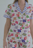 A lady wearing white short sleeve classic cropped pj set with nautical flags print.