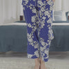 A lady wearing a blue short sleeve cropped pj set with white blossom pattern.