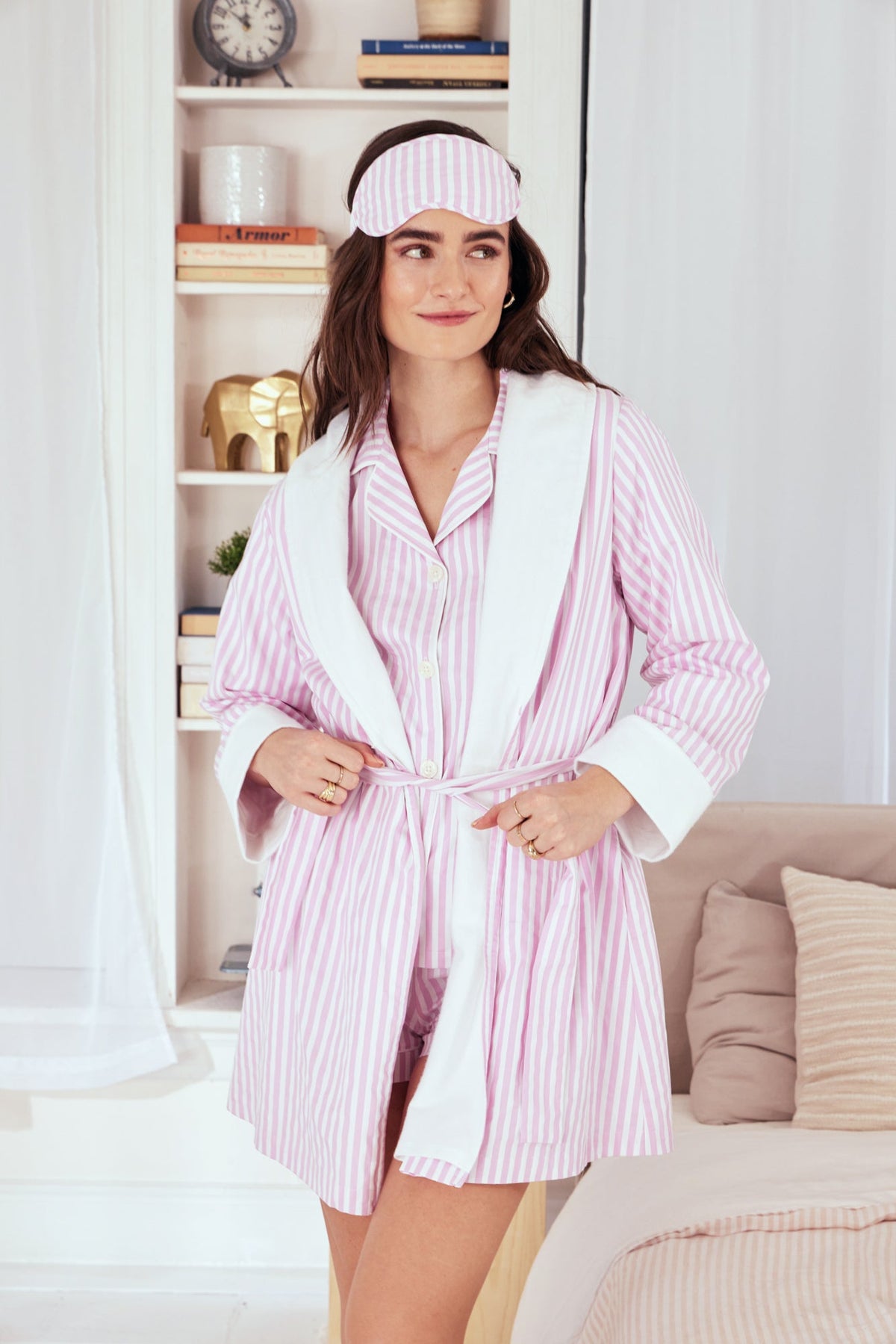 A lady wearing a pink and white stripes robe.