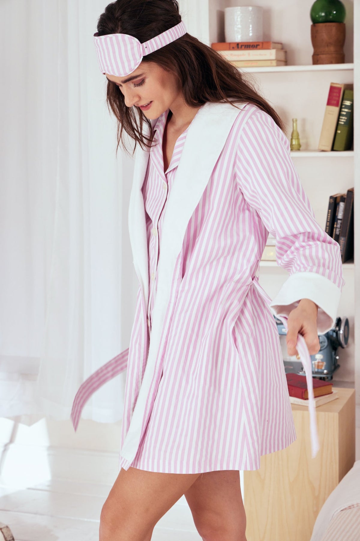 A lady wearing a pink and white stripes robe.