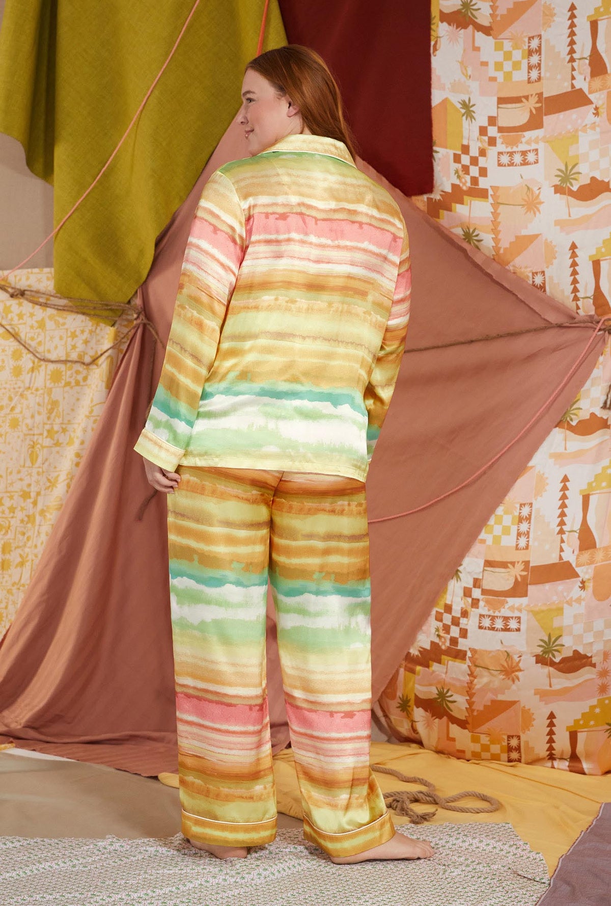 A lady wearing multi color long sleeve classic woven washable silk plus size pj set with island sunset print.