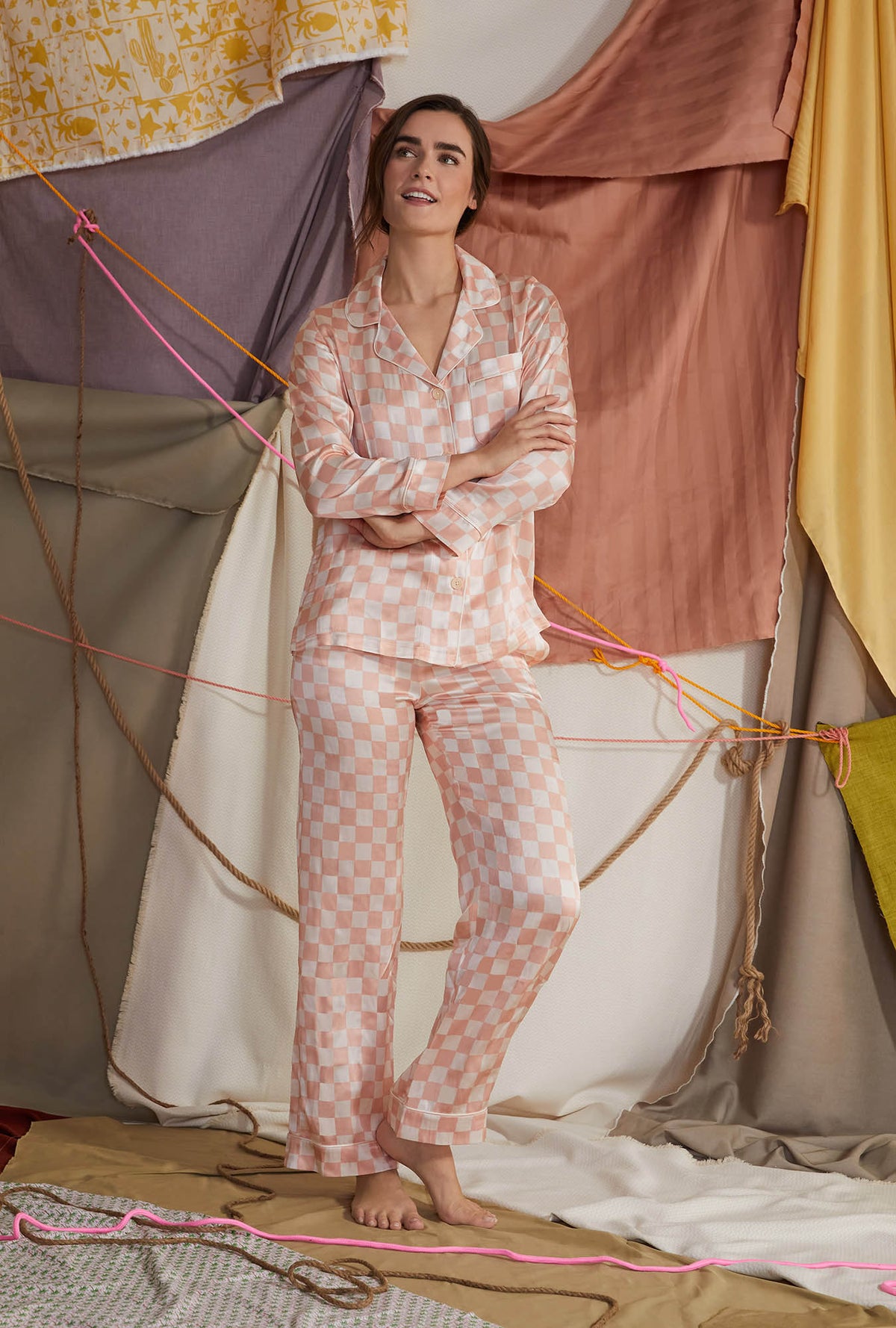 A lady wearing orange long sleeve silk pj set with checkerboard print