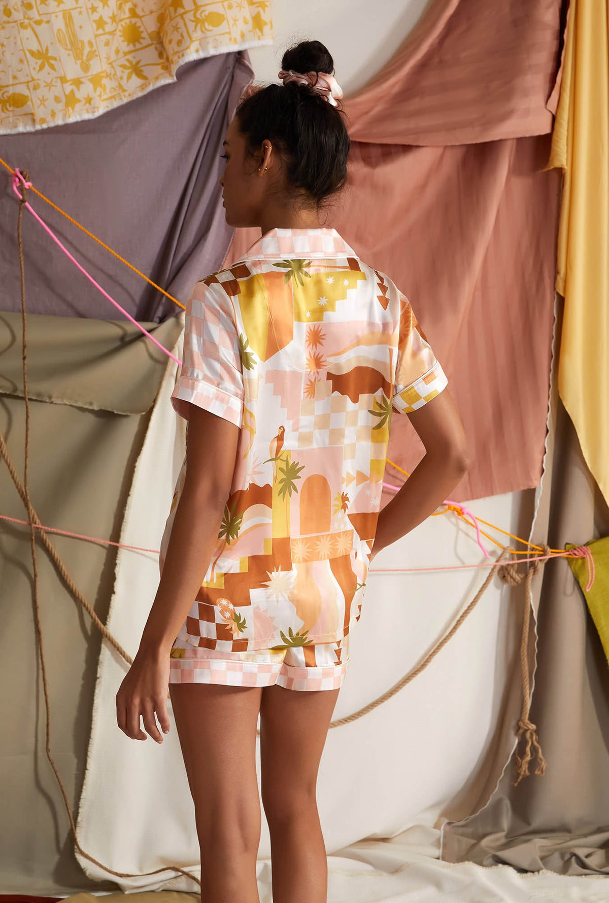 A lady wearing yellow short sleeve silk pj set  with havana print  