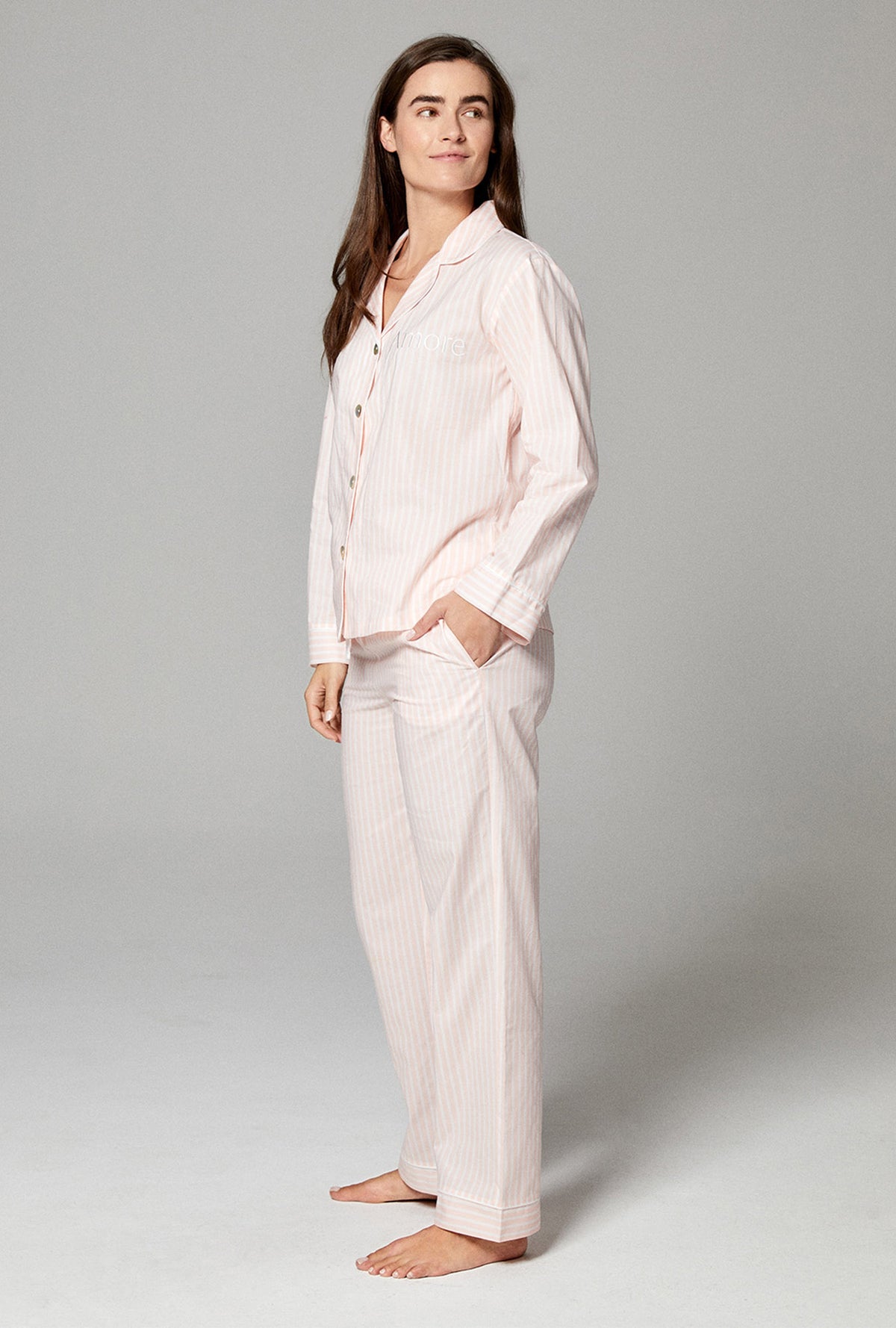 A lady wearing pink long sleeve classic pj set with stripes