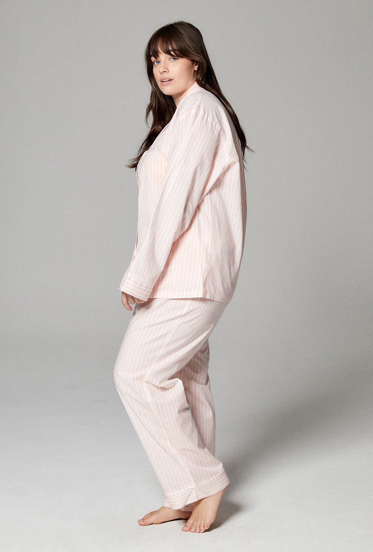A lady wearing pink long sleeve classic pj set with stripes