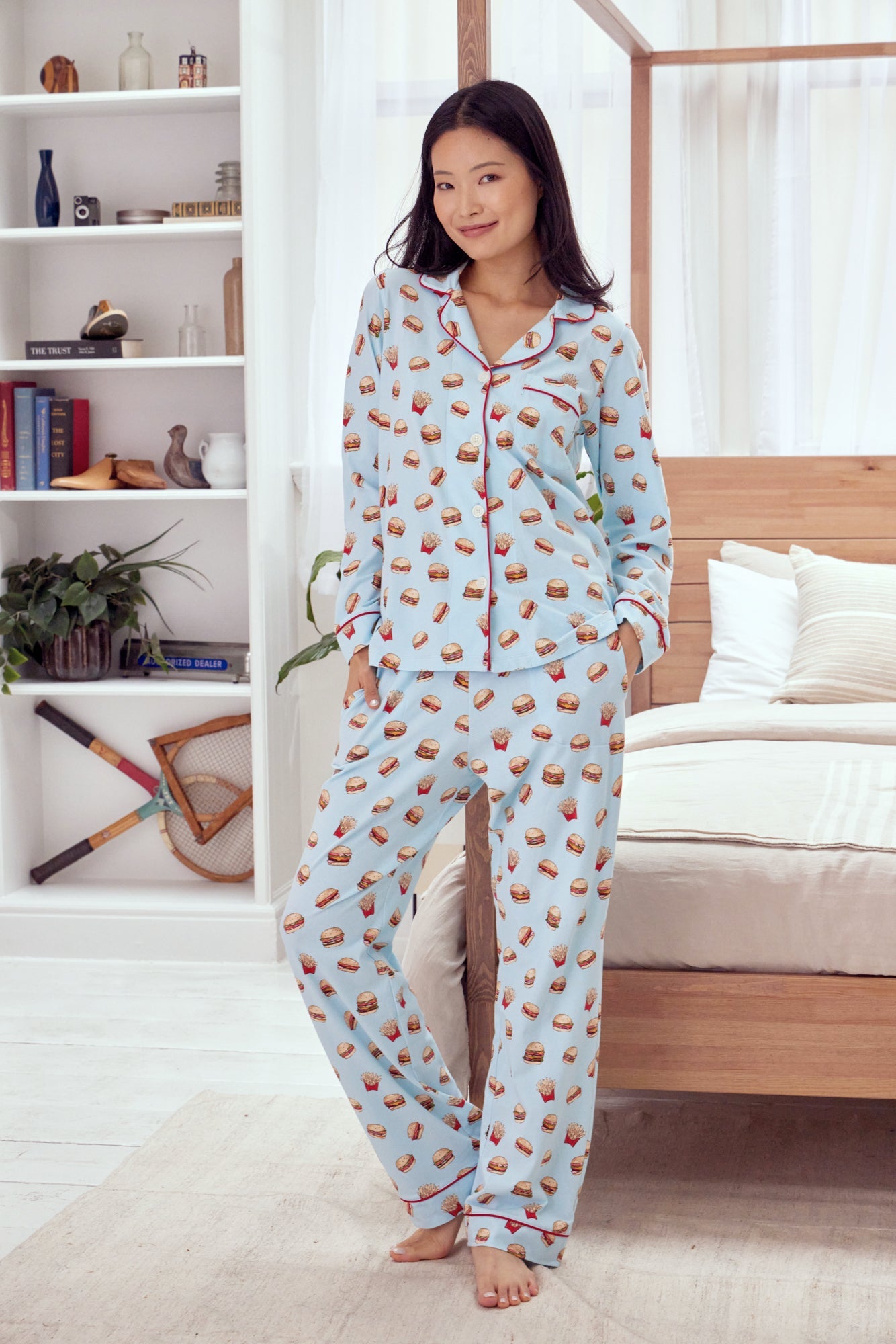 A lady wearing a blue long sleeve pj set with burger and fries pattern.
