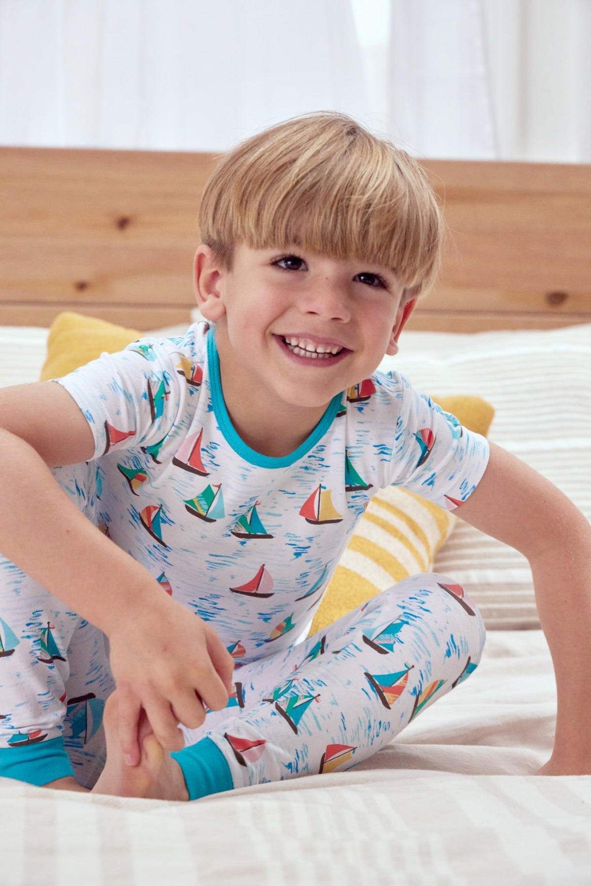 A boy wearing a short sleeve pj set with regatta pattern.