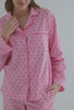 A lady wearing pink long sleeve classic pj set with corsage print