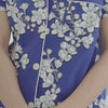 A lady wearing a blue short sleeve shorty plus size pj set with white blossom pattern.