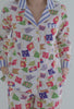 A lady wearing white long sleeve classic pj set with nautical flags print.