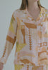 A lady wearing yellow long sleeve silk pj set with havana print