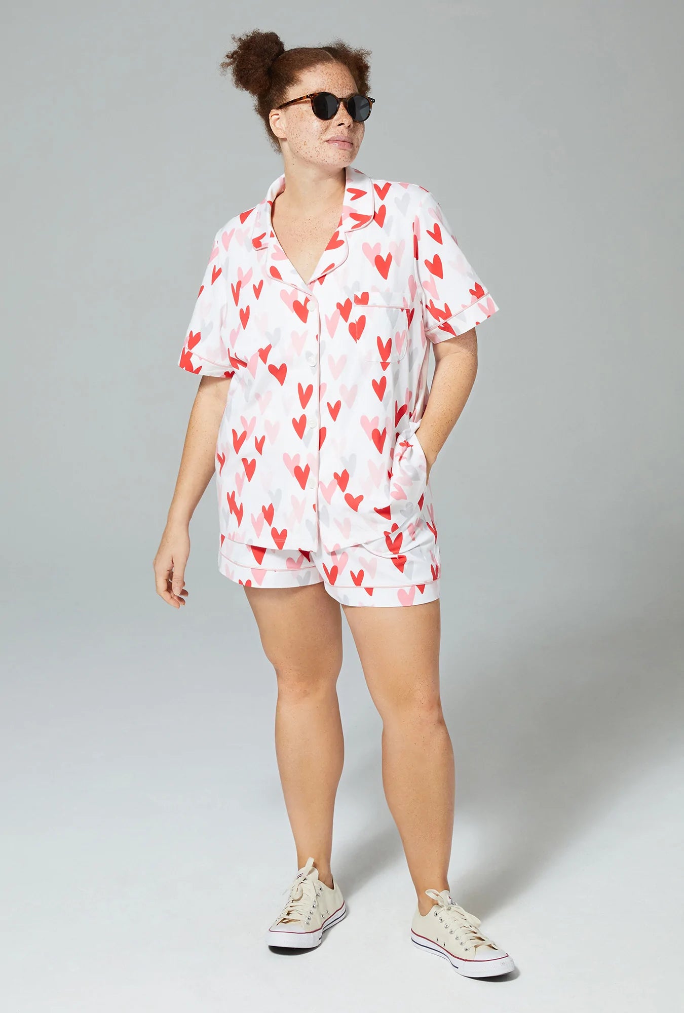A lady wearing white short sleeve classic shorty pj set with pink and red heart prints